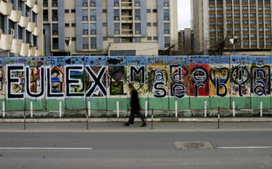 Kosovo Albanians walks by a grafiti, reading "Eulex made in Serbia," in the Kosovar capital of Pristina on December 8, 2008.The EU agreed in February 2008 to send the 2,000-strong EULEX mission to Kosovo to gradually replace a United Nations operation and oversee the police, judiciary and customs. The UN Security Council last week gave a green light to the planned EU mission, which is likely to start its operation in Kosovo on December 9, 2008 under the UN umbrella.AFP PHOTO/ARMEND NIMANI (Photo credit should read Armend Nimani/AFP/Getty Images)